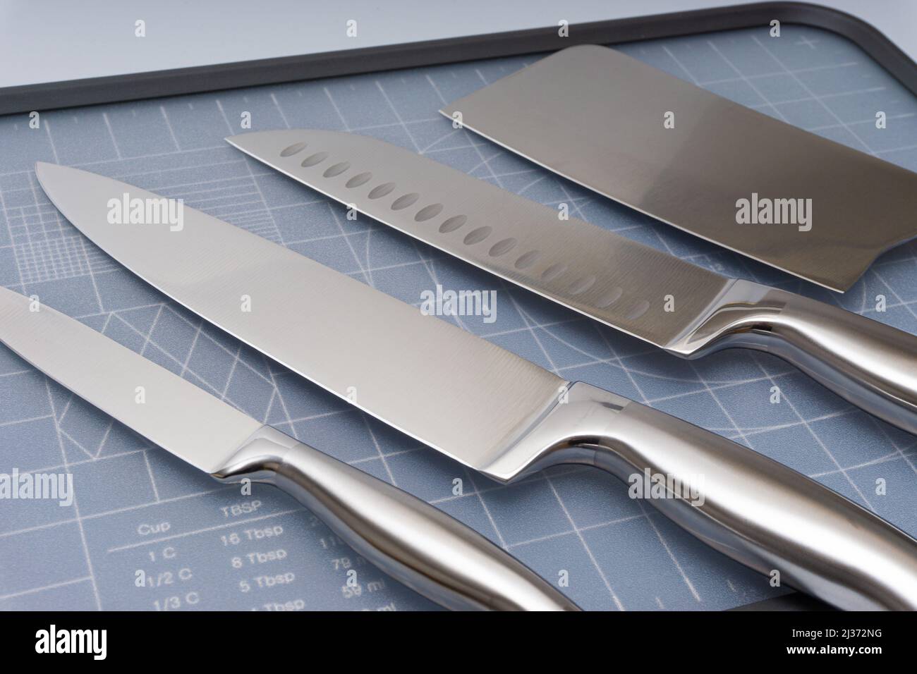 Various kitchen knives, scissors and cutting board Stock Photo