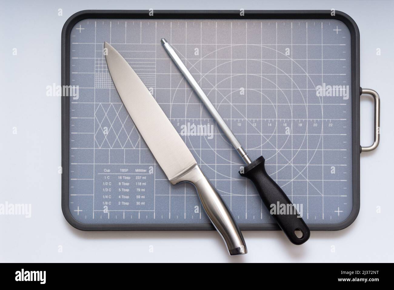 Various kitchen knives, scissors and cutting board Stock Photo