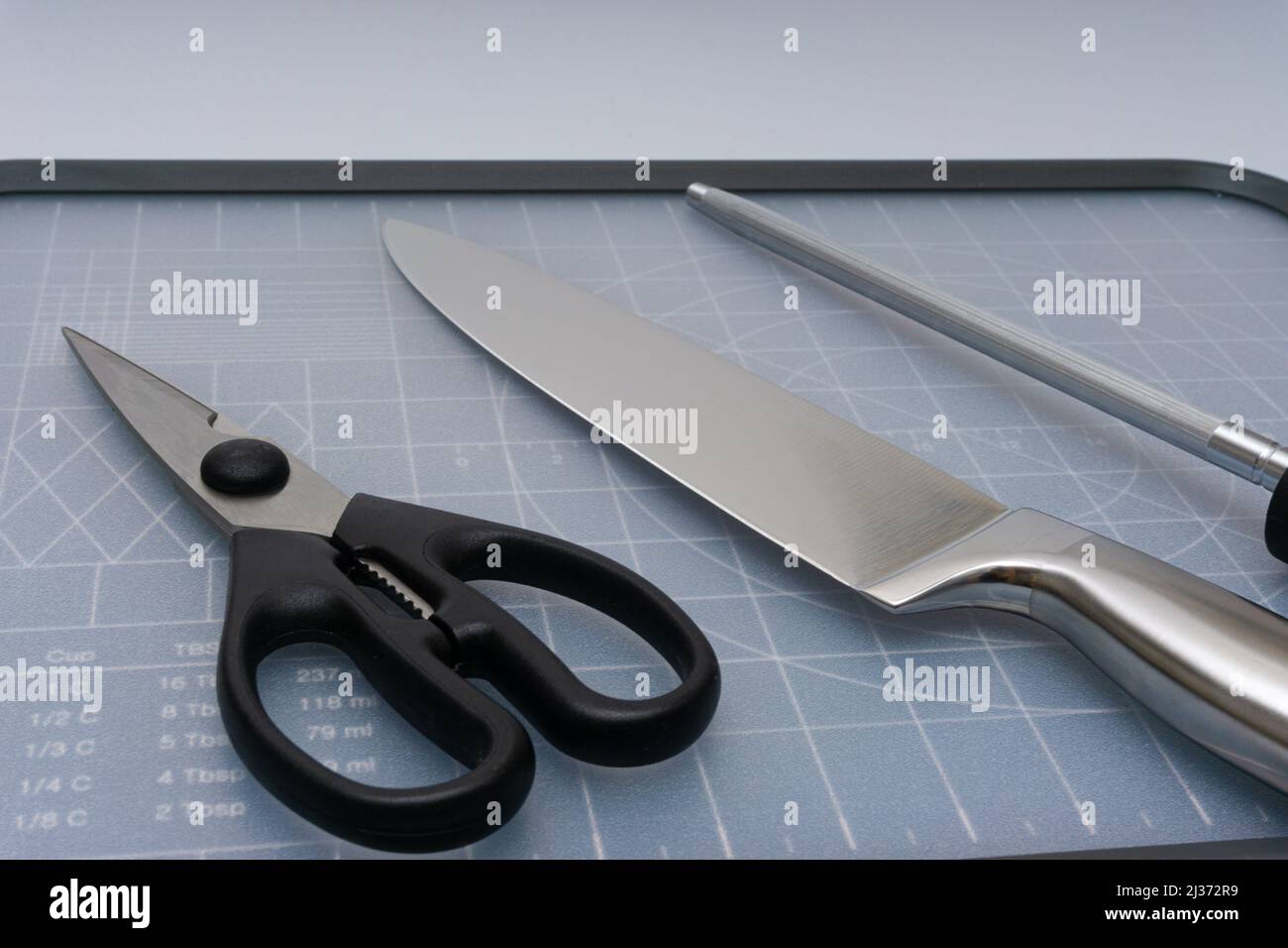 Various kitchen knives, scissors and cutting board Stock Photo