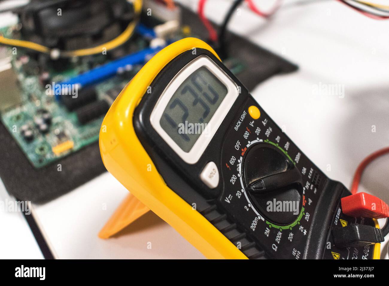 Detail of a multimeter with a computer motherboard in background Stock Photo Alamy