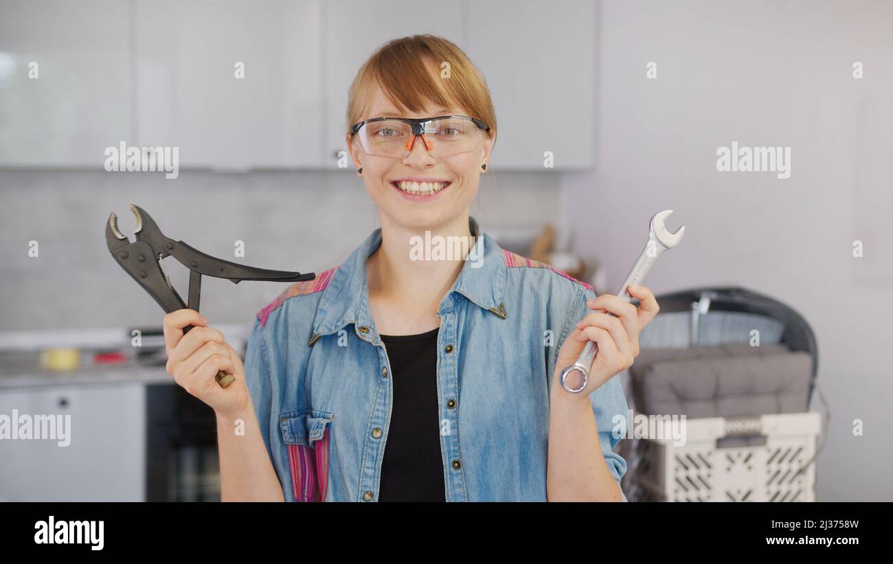 Happy smiling red-haired caucasian woman with tools looking at camera. High quality photo Stock Photo