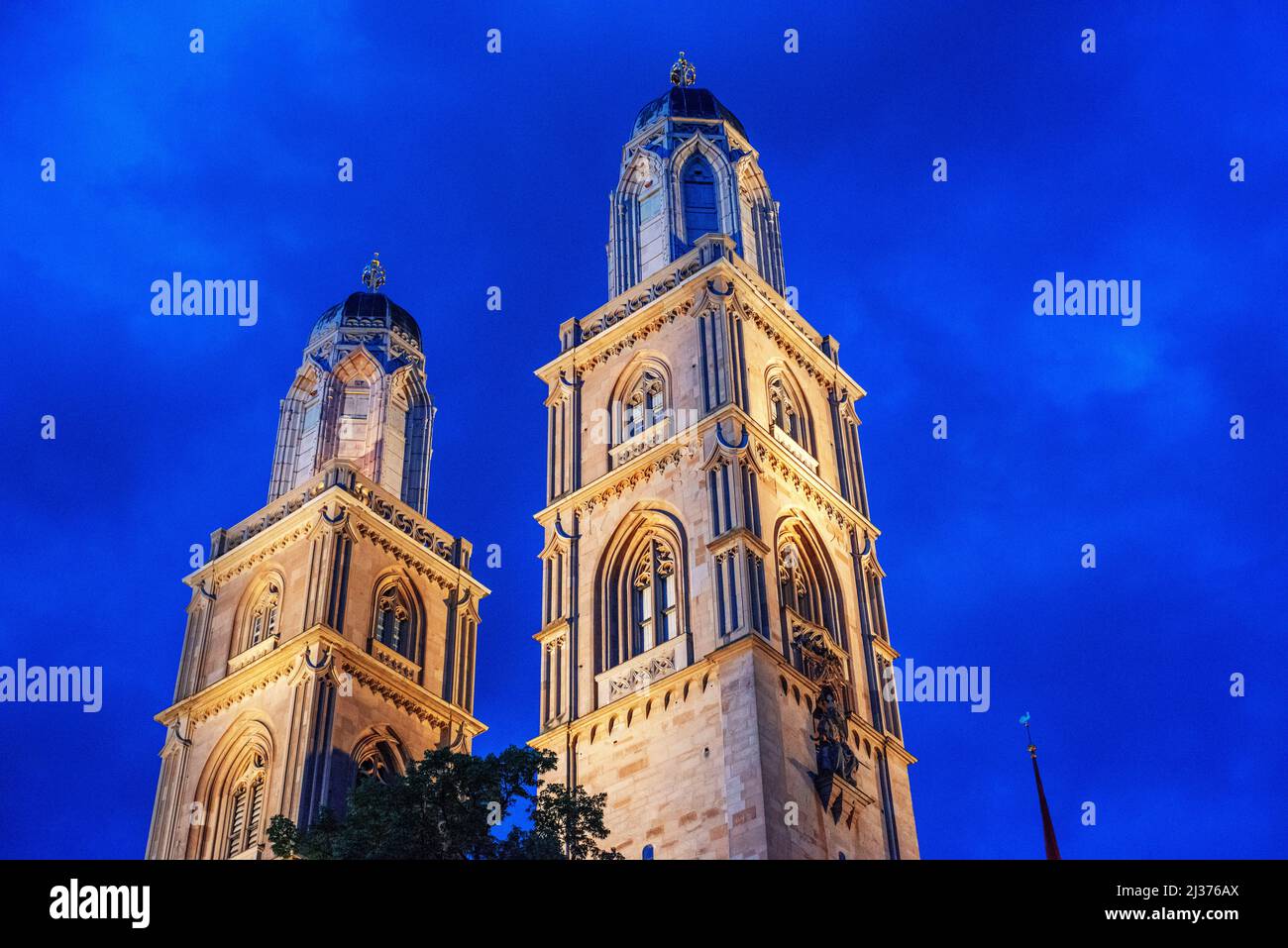 The cityscape of Zurich at night with the river Limmat and the Grossmuenster cathedral, Zurich Switzerland, Europe. Stock Photo