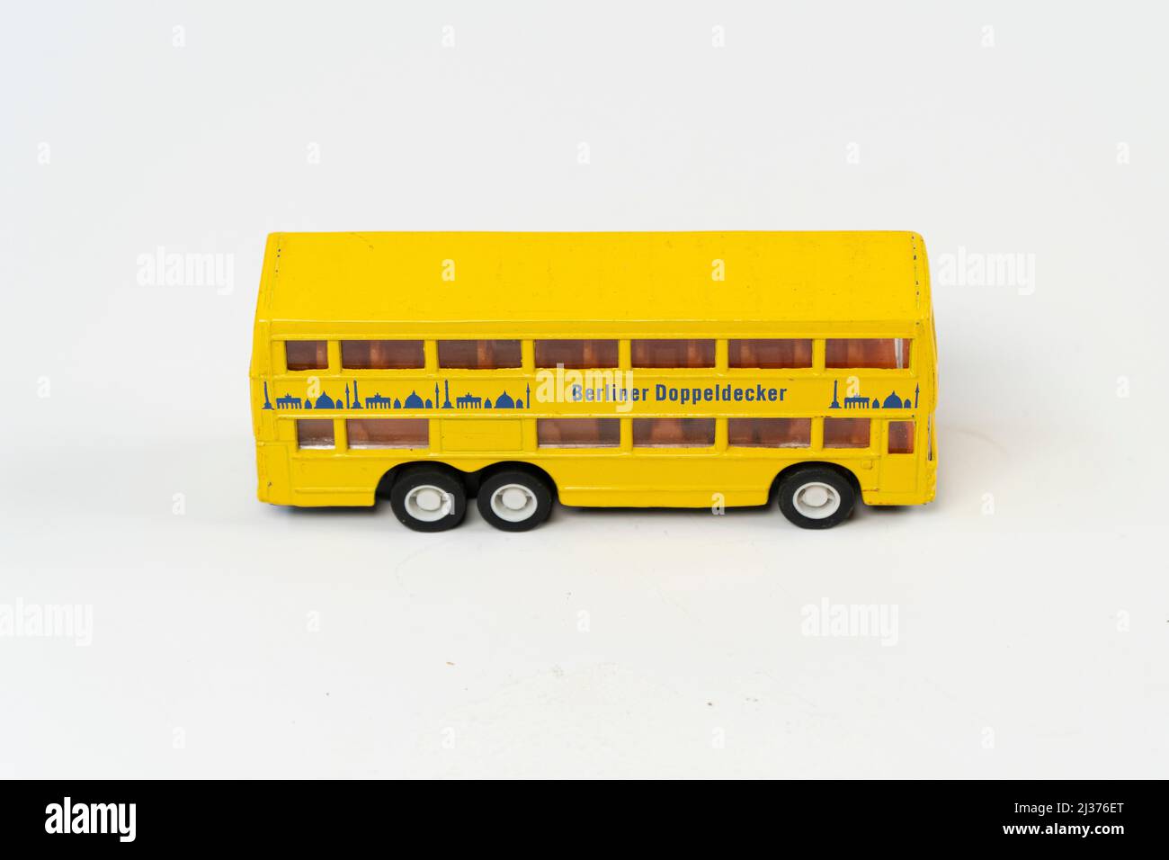 Miniature yellow tporist big bus isolated on white background, double decker metal bus mini toy front view, slanted angle object Stock Photo