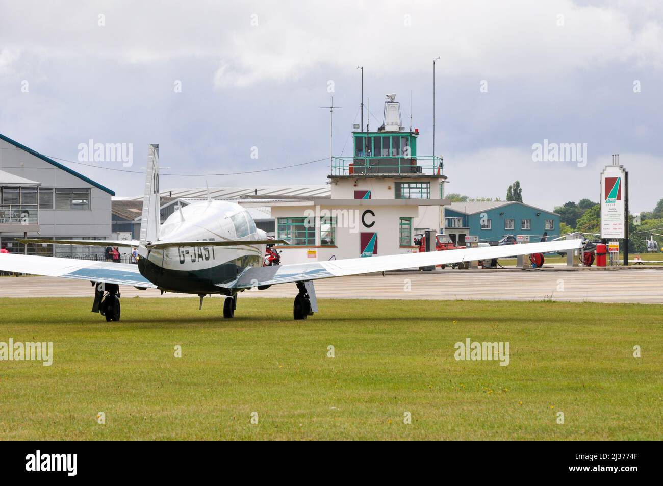 Mooney light aircraft plane outside the hangars and control tower at Sywell Aerodrome, Northamptonshire, UK, during a Royal Aero Club air race Stock Photo