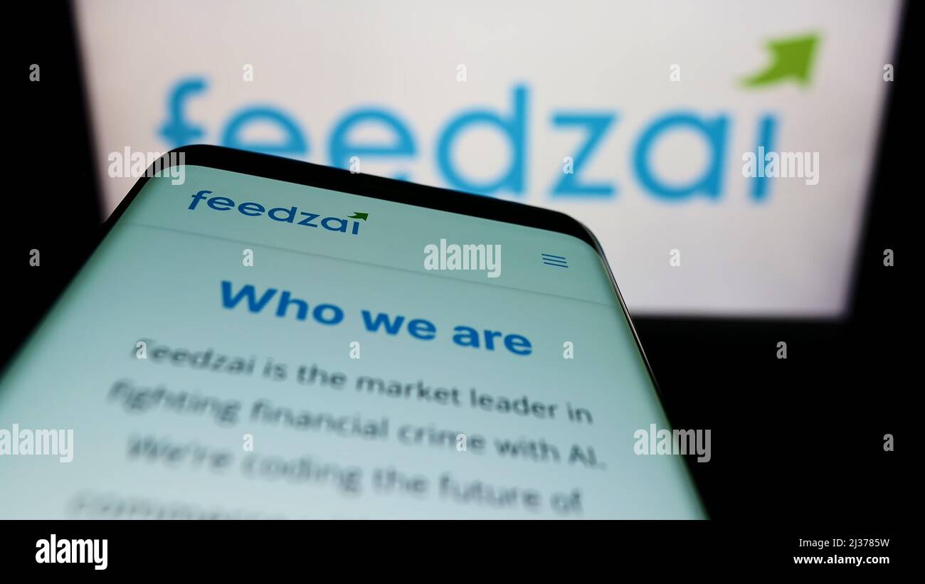 Mobile phone with webpage of Portuguese risk management company Feedzai on screen in front of business logo. Focus on top-left of phone display. Stock Photo