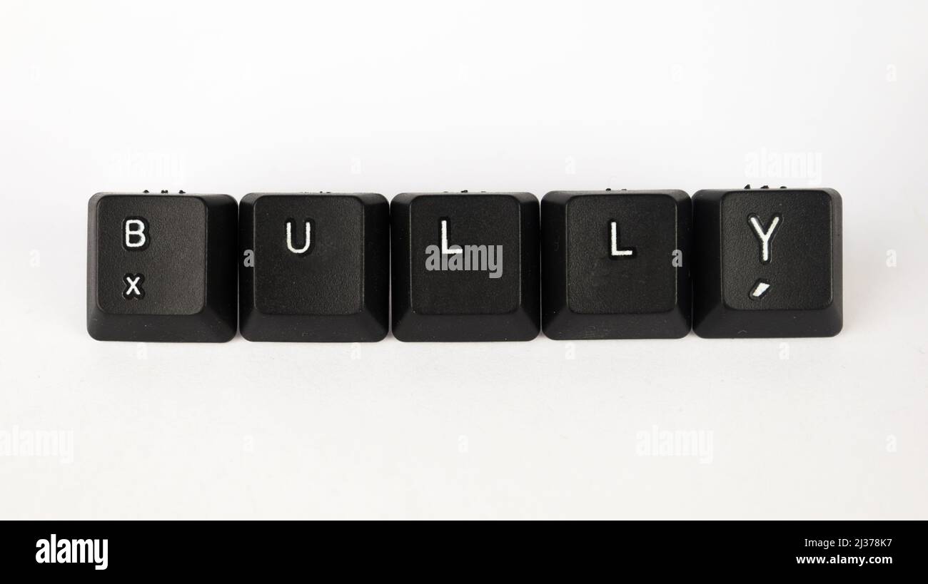 Bully text created with keyboard keys isolated on white background, white bully on black keyboard, top view Stock Photo