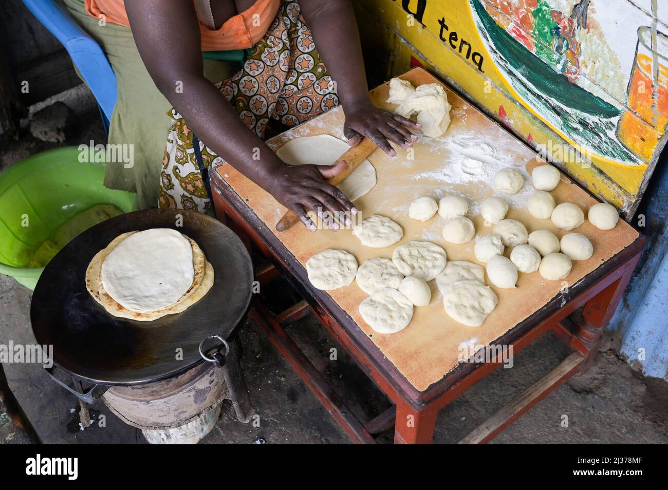 KENYA, Nairobi, Mathare Slum, woman roll and bake and sell flat bread