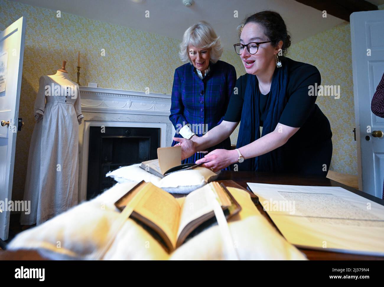 Lizzie Dunford shows the Duchess of Cornwall a first edition copy of Pride and Prejudice alongside the letter Jane Austen wrote to her sister Cassandra in 1813 stating that she had received her 'own darling child from London' - her first copy of Pride and Prejudice during a visit to Jane Austen's House in Alton, Hampshire. Picture date: Wednesday April 6, 2022. Stock Photo