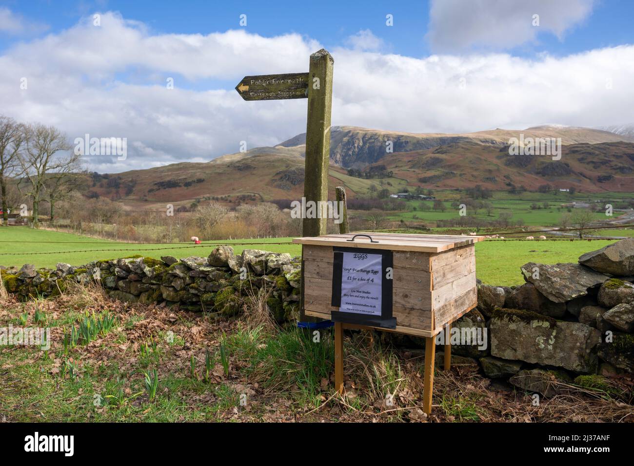 Free range eggs for sale next to a footpath sign to Castlerigg Stone Circle in the Lake District National Park, Cumbria, England. Stock Photo