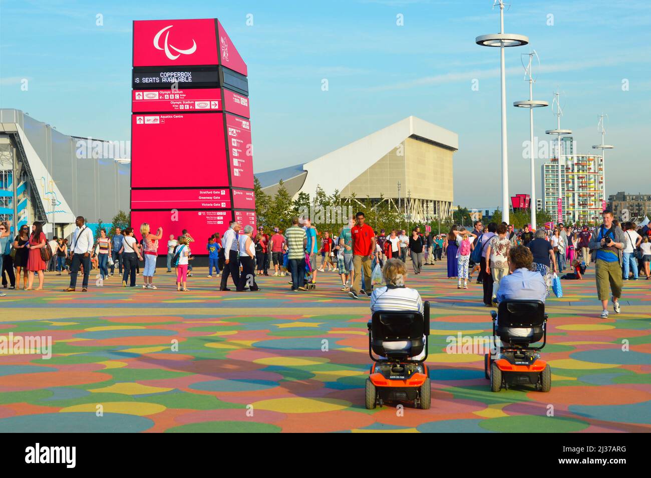London 2012 Olympics disabled visitors & walking spectators move between sports venues in Olympic park at Paralympic Games Stratford Newham England UK Stock Photo
