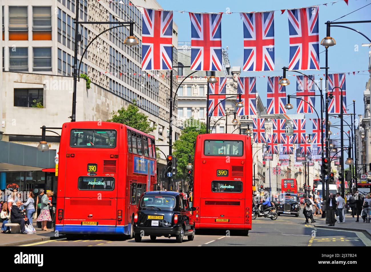 Oxford Street scene London Union Jack Flag display for Queens Jubilee & 2012 Olympics celebrations two red double decker buses & black cab England UK Stock Photo