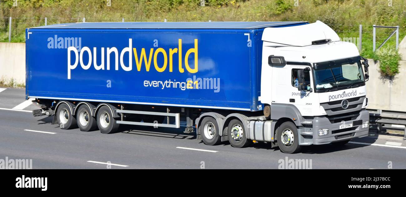 Side front view white Mercedes hgv lorry truck & blue poundworld brand advertising everything £1 on side of articulated delivery trailer on motorway Stock Photo