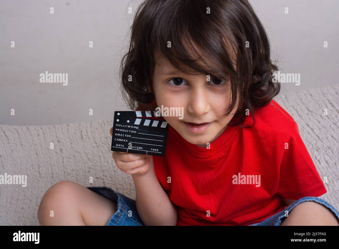 A movie production clapper board in the hand of little boy. Stock Photo