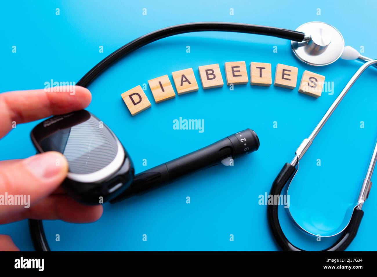 Diabetes wooden text. Flat lay composition with glucose meter and stethoscope on light blue background. Space for text. Stock Photo
