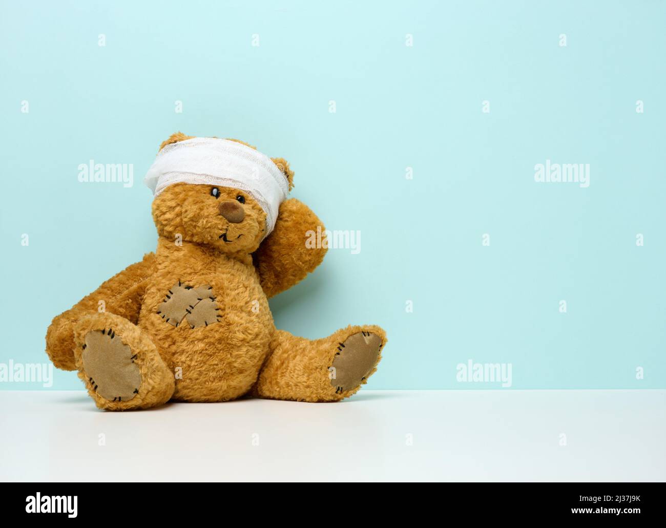 children's toy teddy bear sits with a bandaged head. Childhood trauma