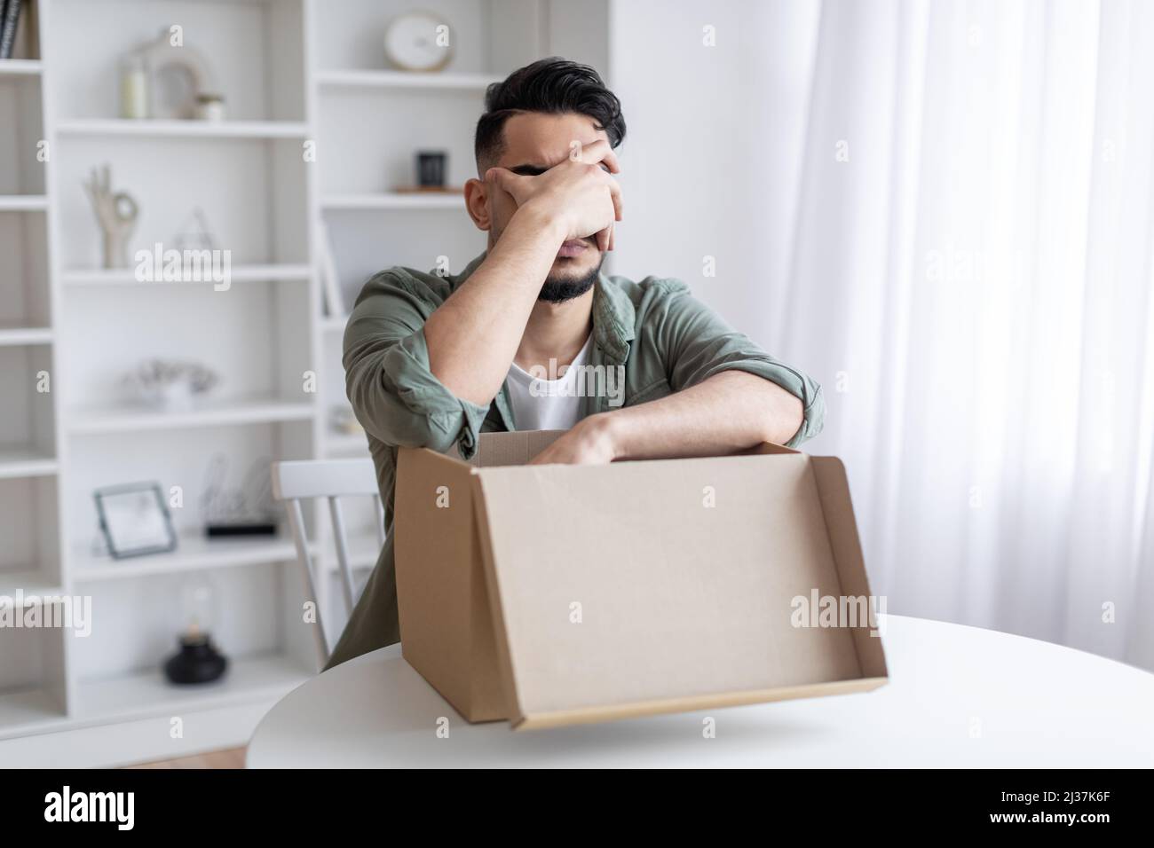 Wrong Item. Upset Arab Guy Opening Parcel And Making Facepalm Gesture Stock Photo