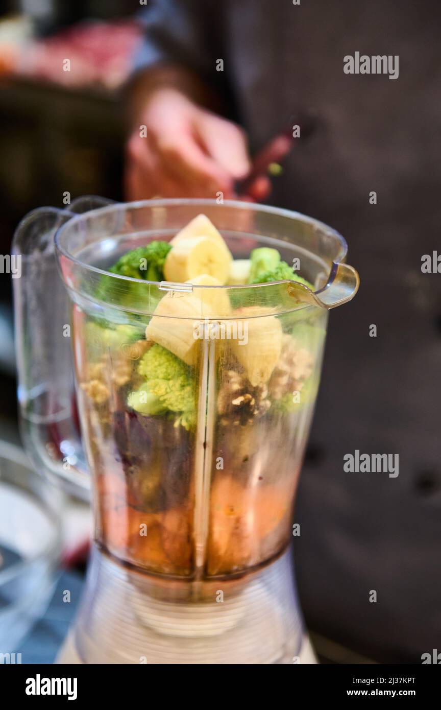 Banana broccoli and different types of fruits in the blender to make a