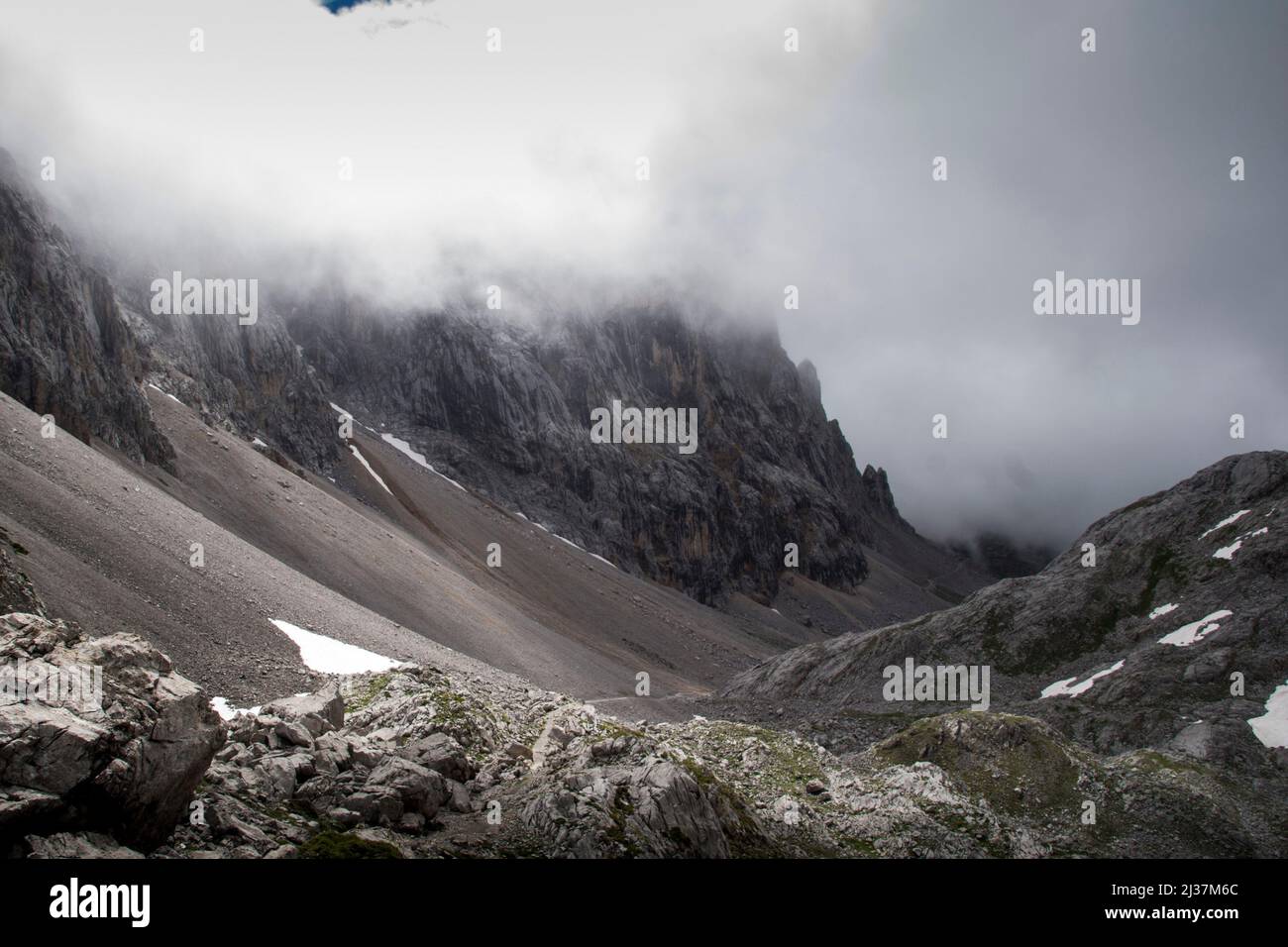Imposing and majestic sharp limestone peaks stand tall amidst the fog clearing and revealing the light Stock Photo