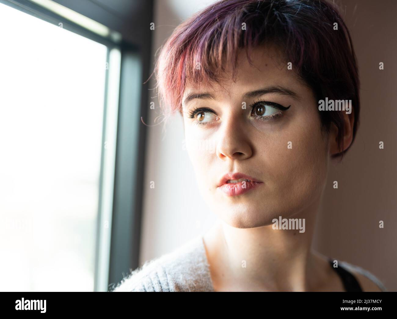 Home fashion portrait of a 23 year old white woman with short, dyed hair, Brussels, Belgium. Stock Photo