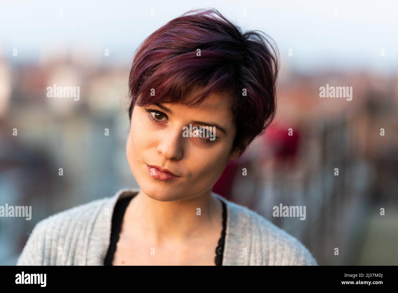 Fashion portrait of a 23 year old white woman with short, dyed hair standing on a terrace, Brussels, Belgium. Stock Photo