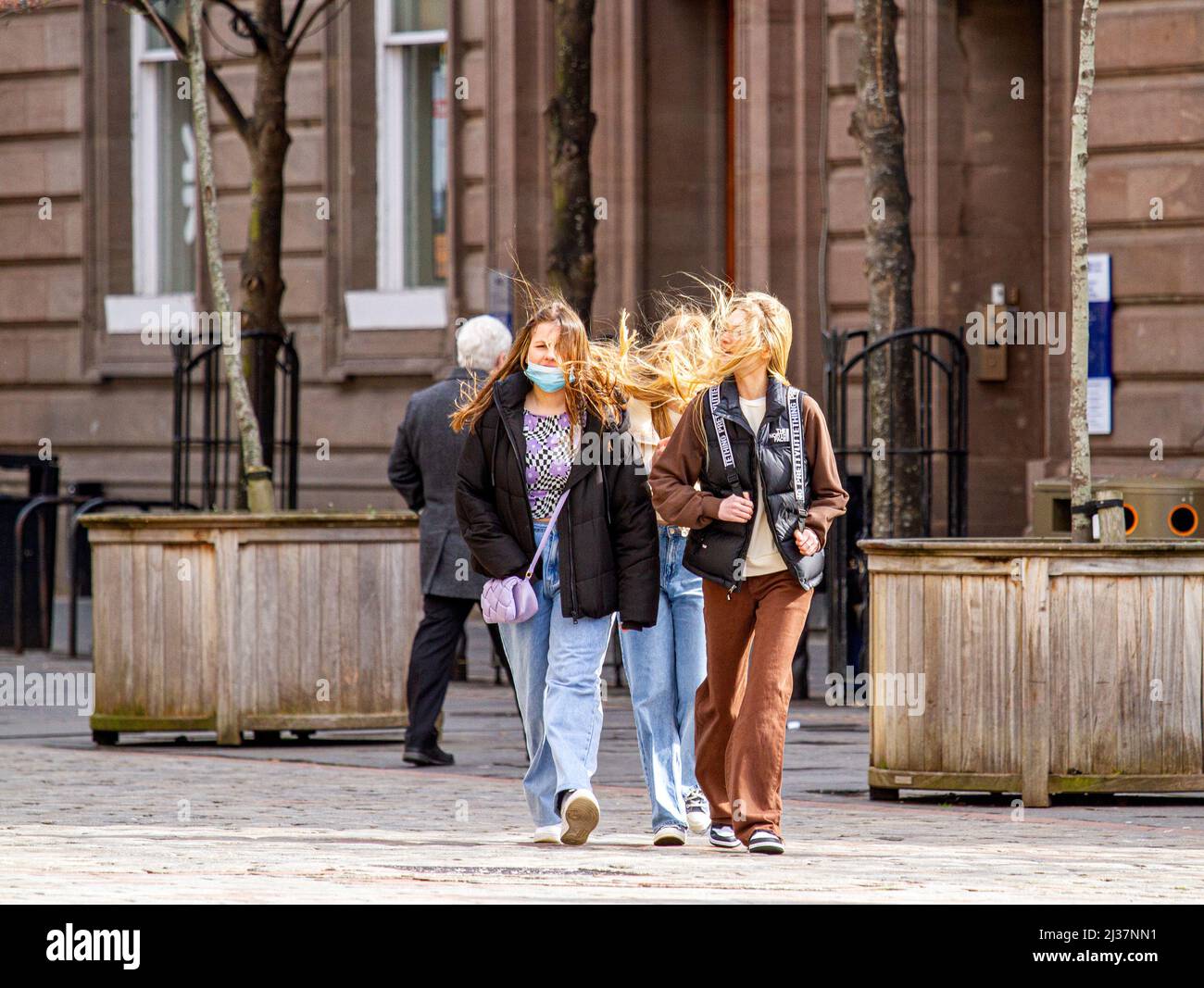 Dundee, Tayside, Scotland, UK. 6th Apr, 2022. UK Weather: Temperatures in North East Scotland reached 14°C, thanks to a strong sea breeze and warm Spring sunshine. Locals are out and about in Dundee's city centre enjoying the April weather while having a good time socialising, but young women's hair blow in the wind, giving them a bad hair day. Credit: Dundee Photographics/Alamy Live News Stock Photo