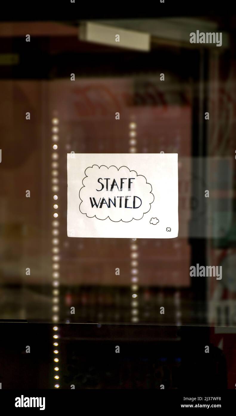 Handwritten sign in the window of a business advertising for staff. No people. Stock Photo