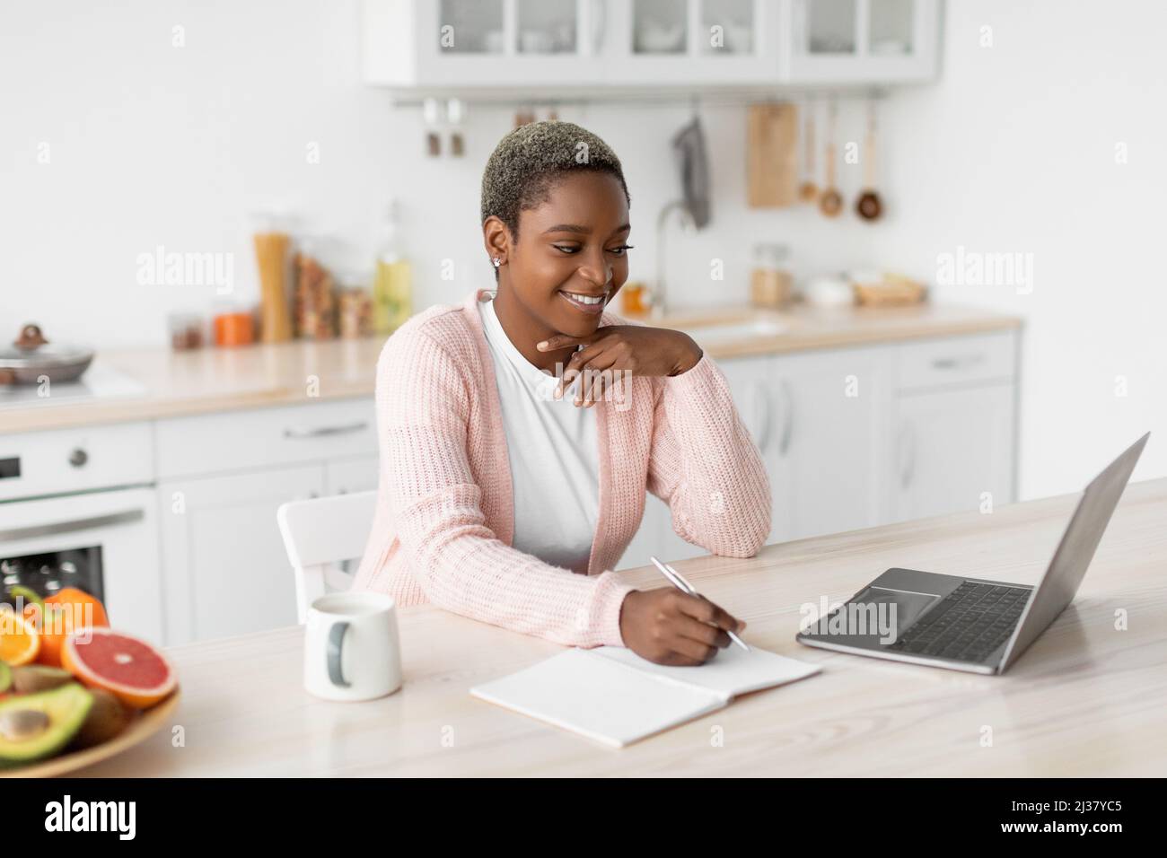 Smiling young pretty african american businesswoman working with laptop Stock Photo