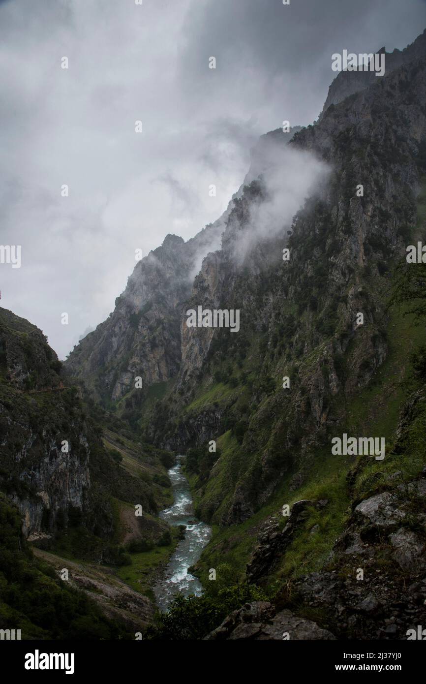 Sharp cliffs of limestone and deep gorges under the clouds in a grey rainy day Stock Photo