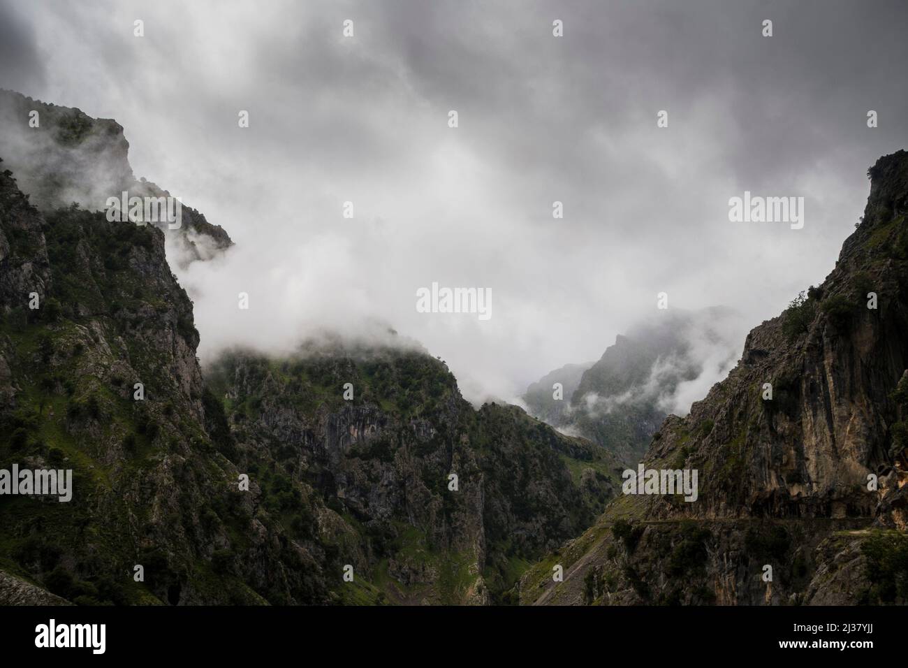 Sharp cliffs of limestone and deep gorges under the clouds in a grey rainy day Stock Photo