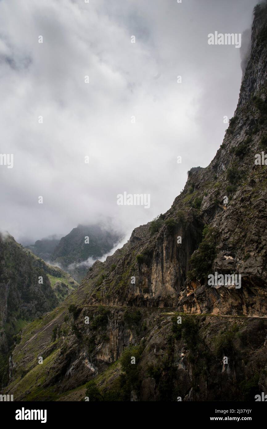 Sharp cliffs of limestone and deep gorges under the clouds in a grey rainy day Stock Photo