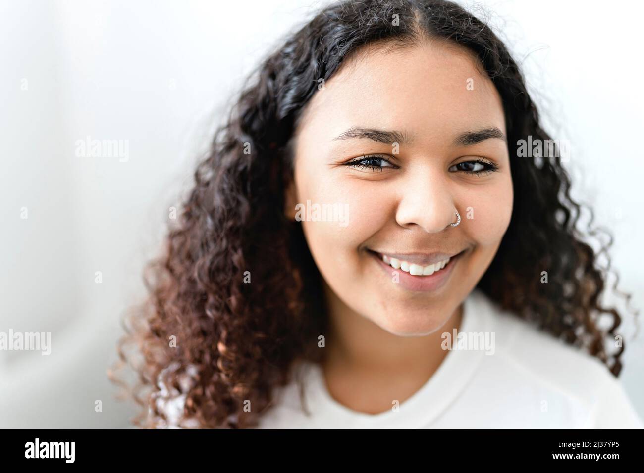 Attractive young African woman sitting on the couch at home Stock Photo ...