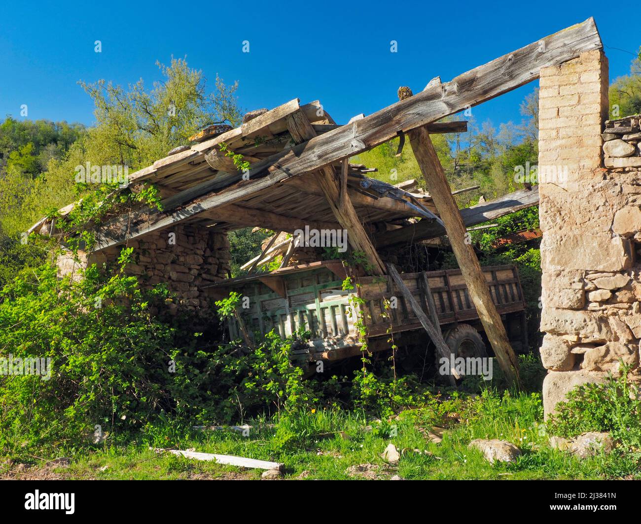 Old farm cart under ruined shed. Perafita village countryside. Lluçanès region, Barcelona province, Catalonia, Spain. Stock Photo