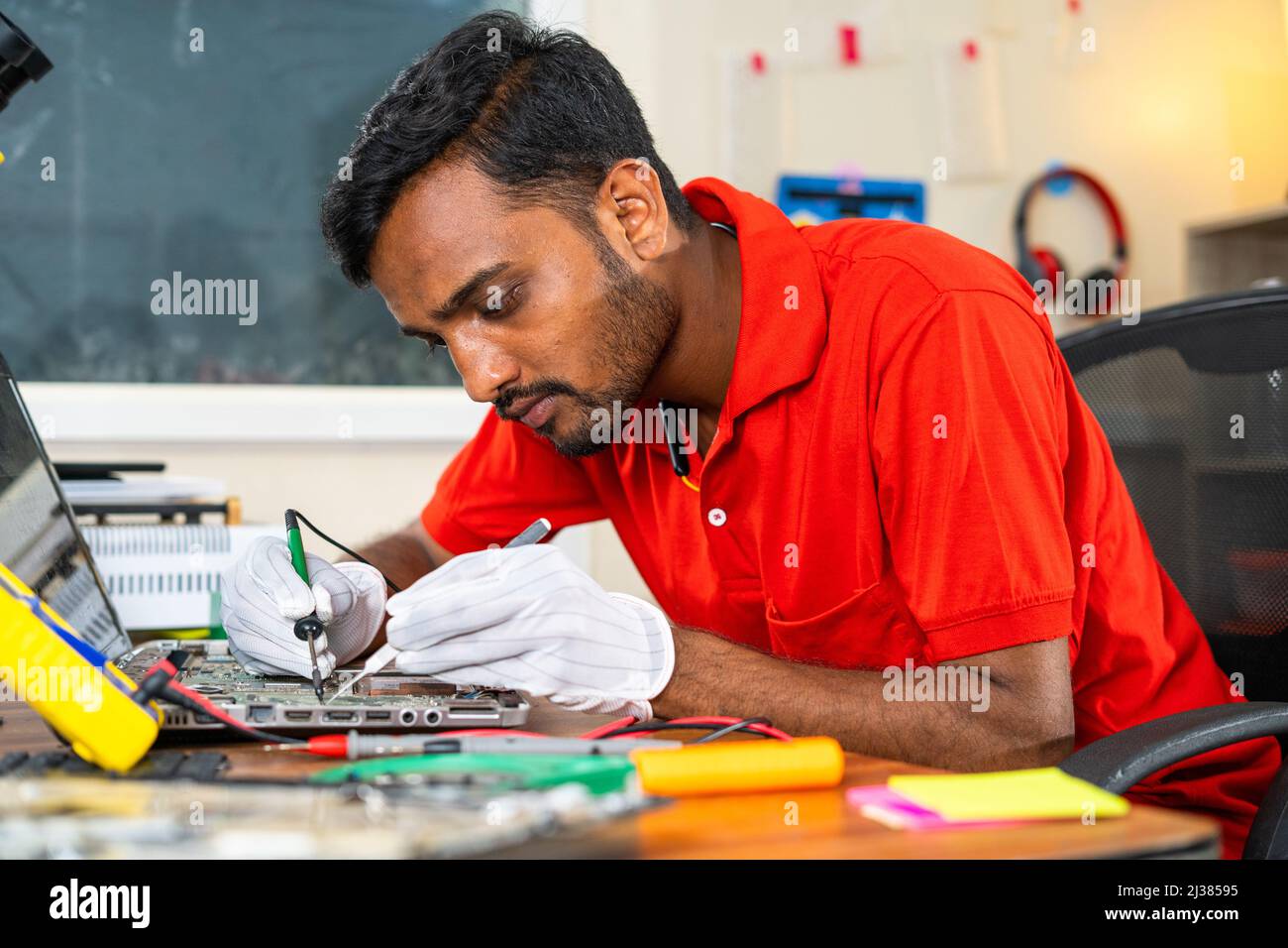 concentrated technician busy reparing laptop at concept of