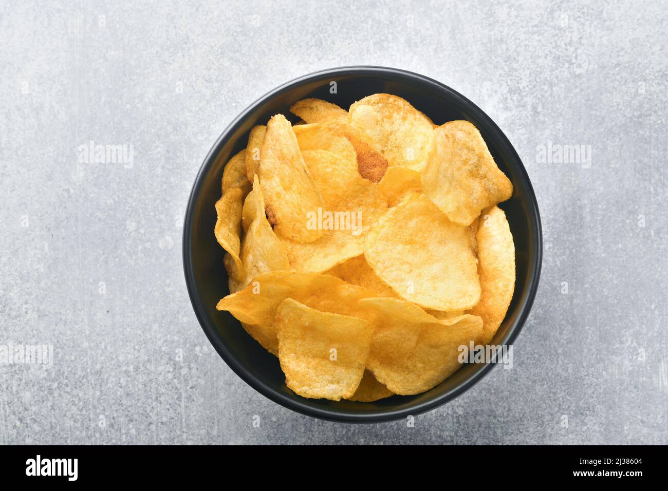 Potato chips. Fast food. Crispy potato chips ceramic black bowl with