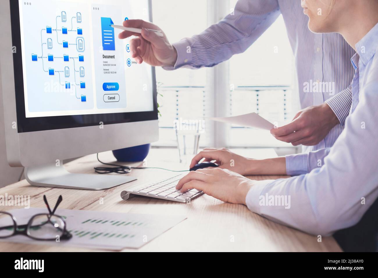 Document management system (DMS) allowing efficient business processes. colleagues working with file manager on computer screen at the office to appro Stock Photo