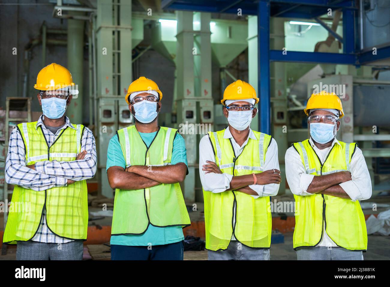 group of Confidently standing industrial workers with arms crossed by