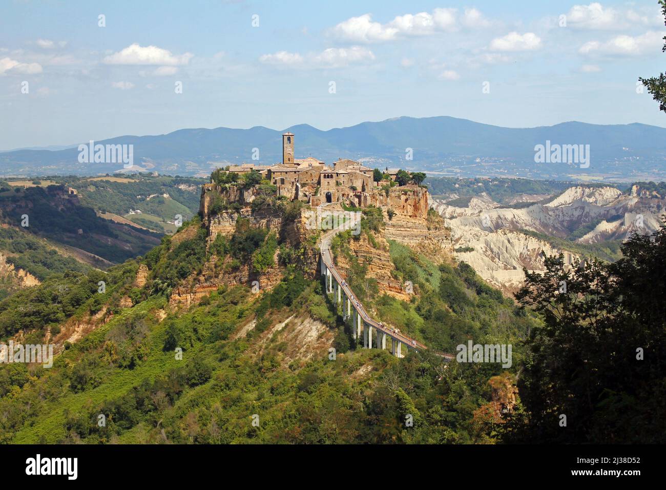 The historical civita village of Bagnoregio standing on a cliff with the long pedestrian bridge in the center of Italy Stock Photo