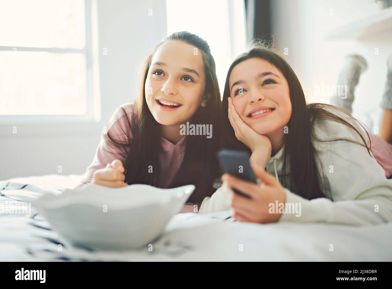 A pajama party with teens eat popcorn on the bed Stock Photo Alamy