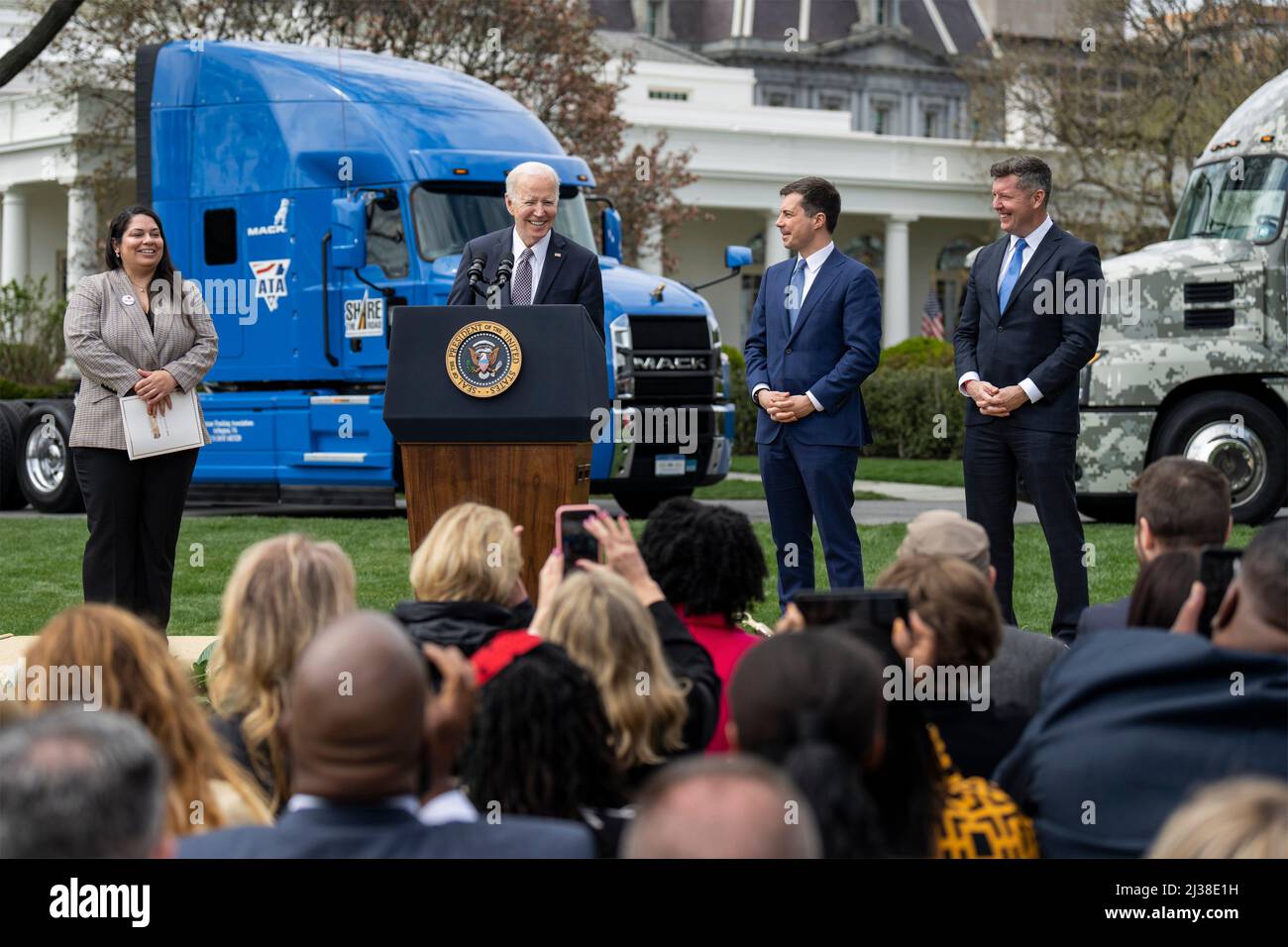 Washington, United States of America. 04 April, 2022. U.S President Joe Biden delivers remarks during an event highlighting federal investments in the trucking industry on the South Lawn of the White House, April 4, 2022 in Washington, D.C. Standing from left to right are: Trucking apprentice Maria Rodriguez, President Joe Biden, Transportation Secretary Pete Buttigieg, and Veterans Trucking Task Force chairman former Rep. Patrick Murphy.  Credit: Adam Schultz/White House Photo/Alamy Live News Stock Photo
