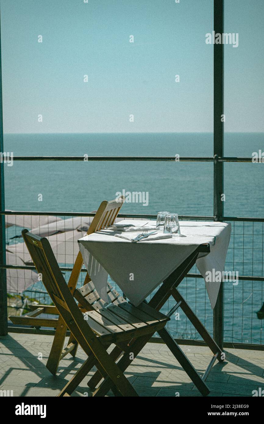 Cozy table for two on the mediterranean coast in Italy Stock Photo