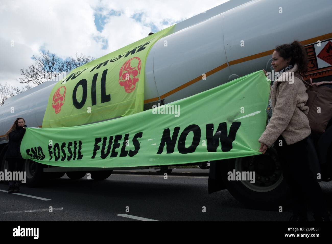 Staines, UK. 6th Apr 2022. Members of Extinction Rebellion climb on top of fuel tankers by the entrance to Esso West London Terminal near Heathrow Airport. Protesters demand an end to fossil fuels. Extinction Rebellion (XR) and Just Stop Oil have been blockading roads used to access oil refineries near London and Birmingham since the weekend and preventing fuel trucks from leaving or entering the fuel depots. Stock Photo