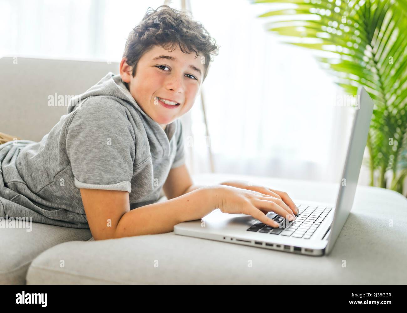 young teenager using laptop on sofa at home Stock Photo - Alamy