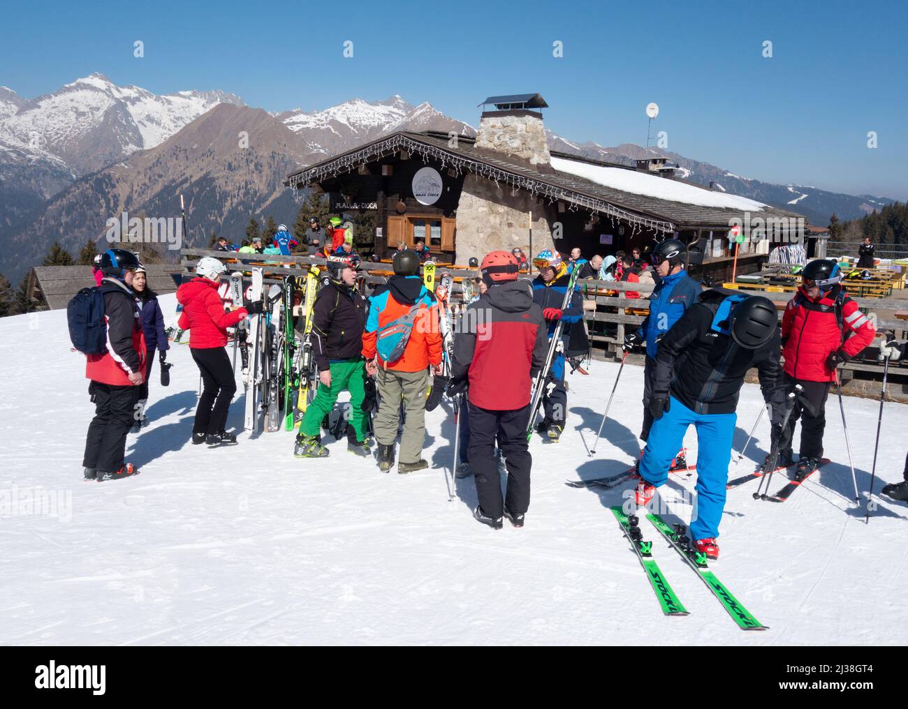 Italy Ski holiday scene - skiers skiing to the Malga Croca mountain restaurant and bar for food and drink, Pinzolo Dolomites Italy Europe Stock Photo