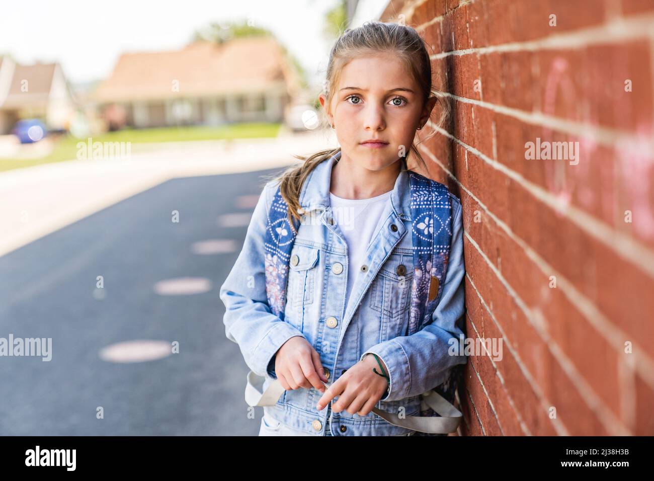 Young children girl on the school playground with backpack Stock Photo