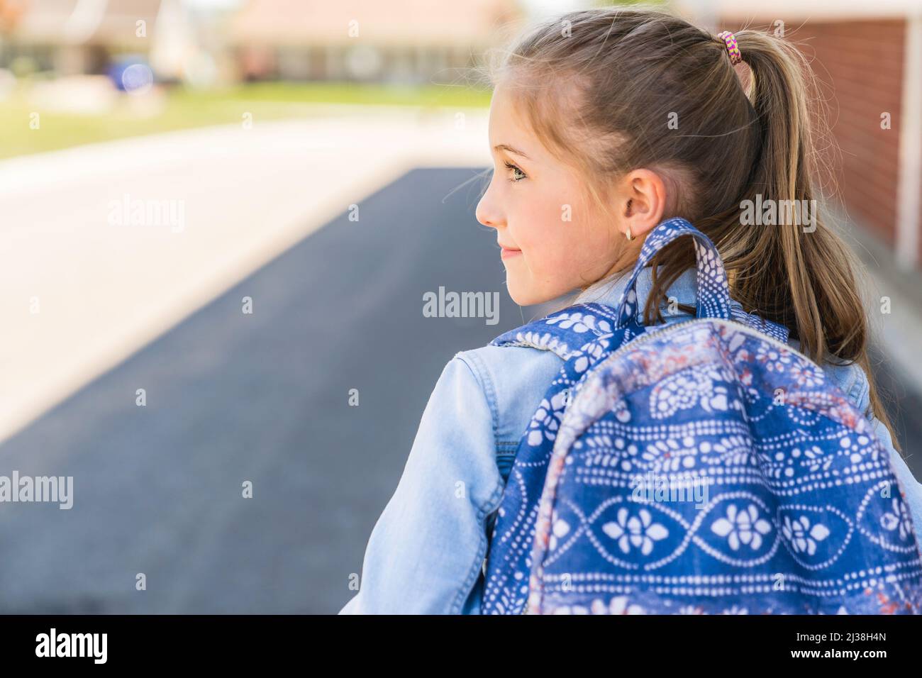 Young children girl on the school playground with backpack Stock Photo