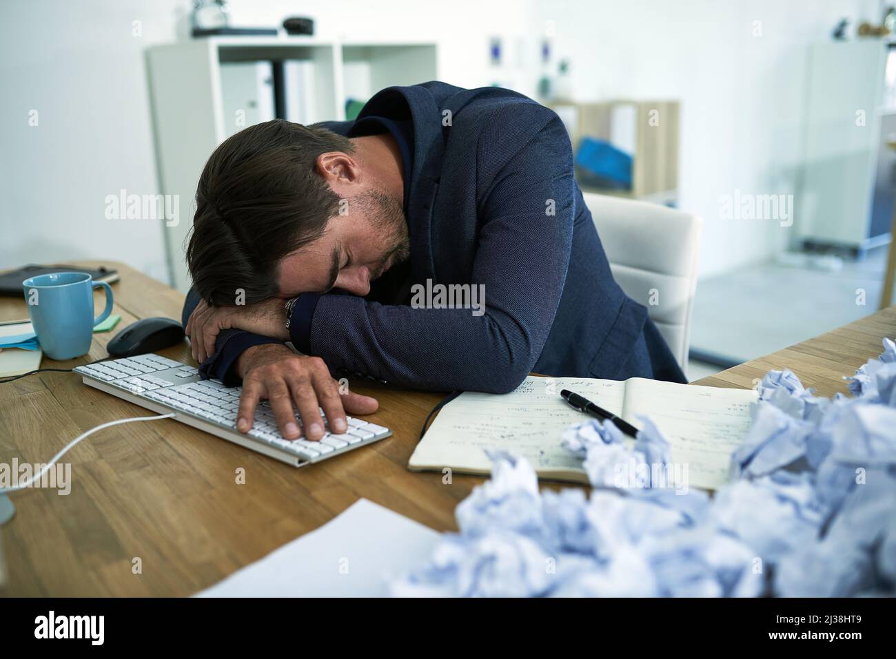 Drowning in paperwork. Shot of a stressed out businessman passed out at