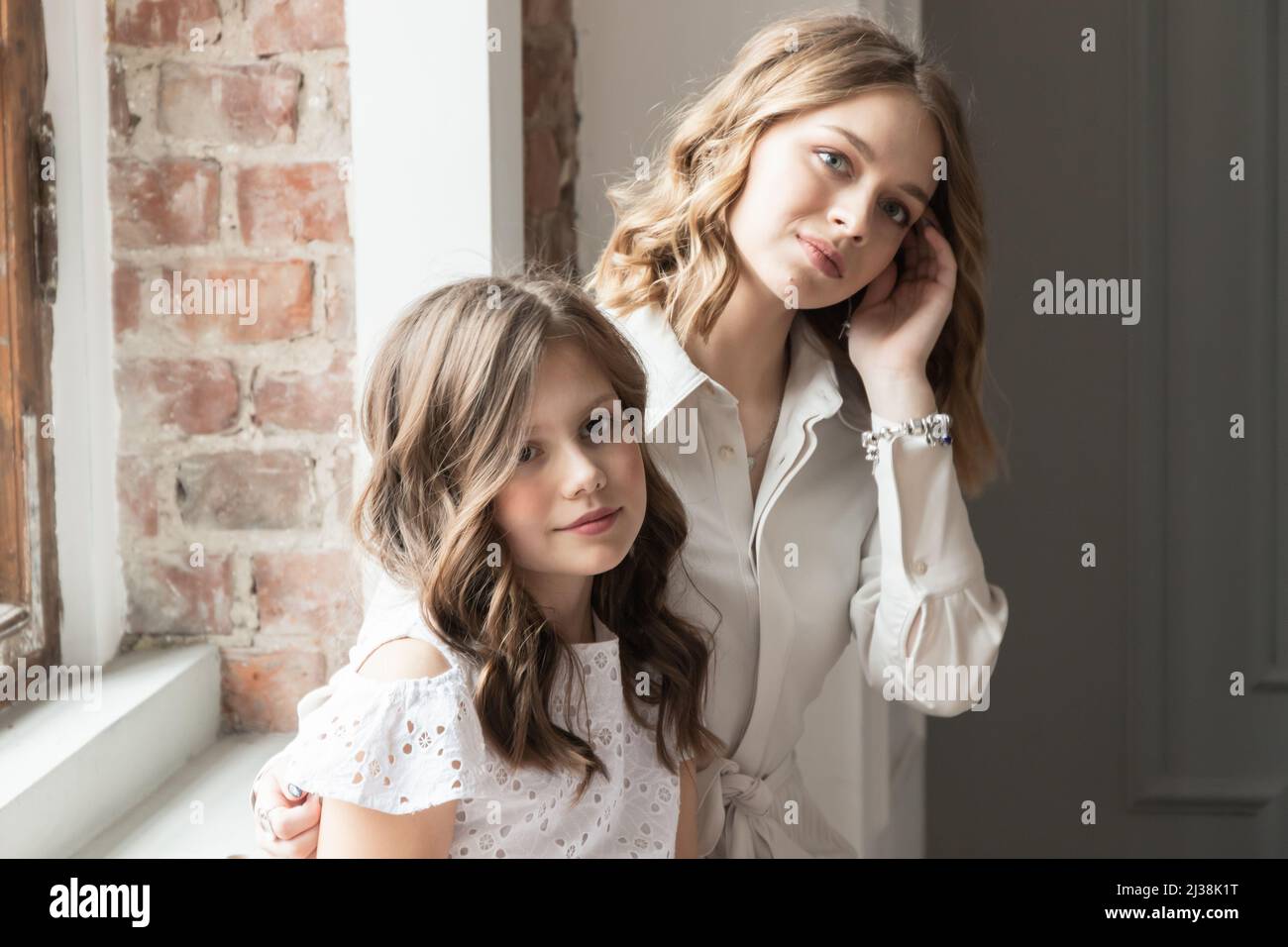 Real sisters, casual studio portrait of two beautiful European girls, soft selective focus Stock Photo