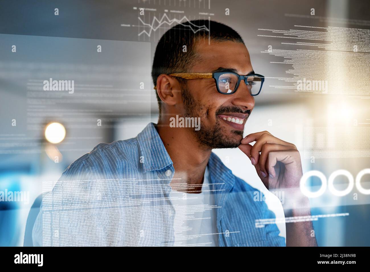 Binary is his second language. Shot of a happy computer programmer working on new software at his computer. Stock Photo