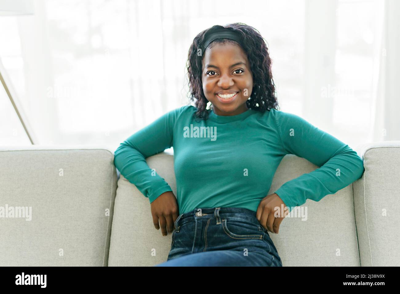 Beautiful African American woman sit on the sofa at home Stock Photo ...
