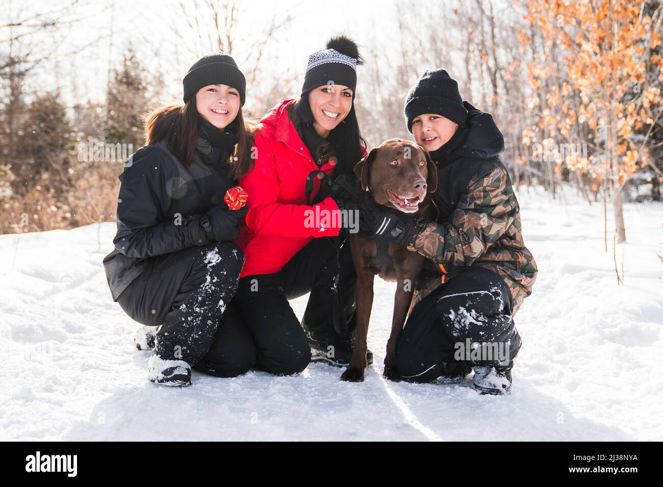 Portrait of family with labrador dog in winter season Stock Photo